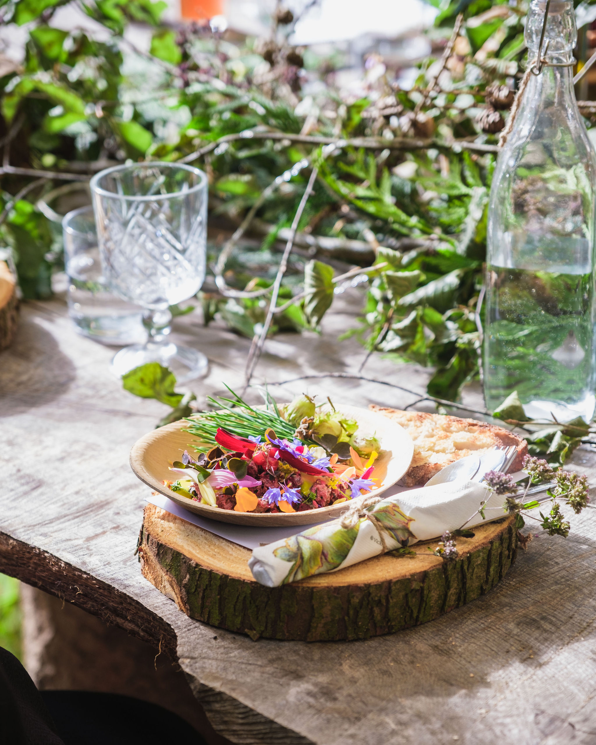 A plate filled with colorful vegetation gathered from Nomadic's woodland, served in the signature wood plate