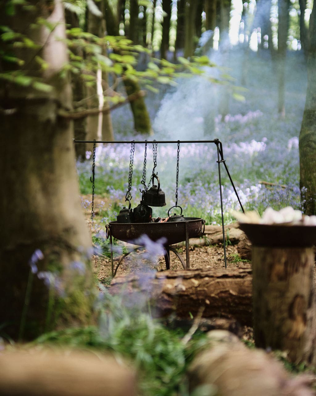 Four kettles hanging in chains over a fire, surrounded by Nomadic's woodland for Meta's World Earth Day Corporate Experience